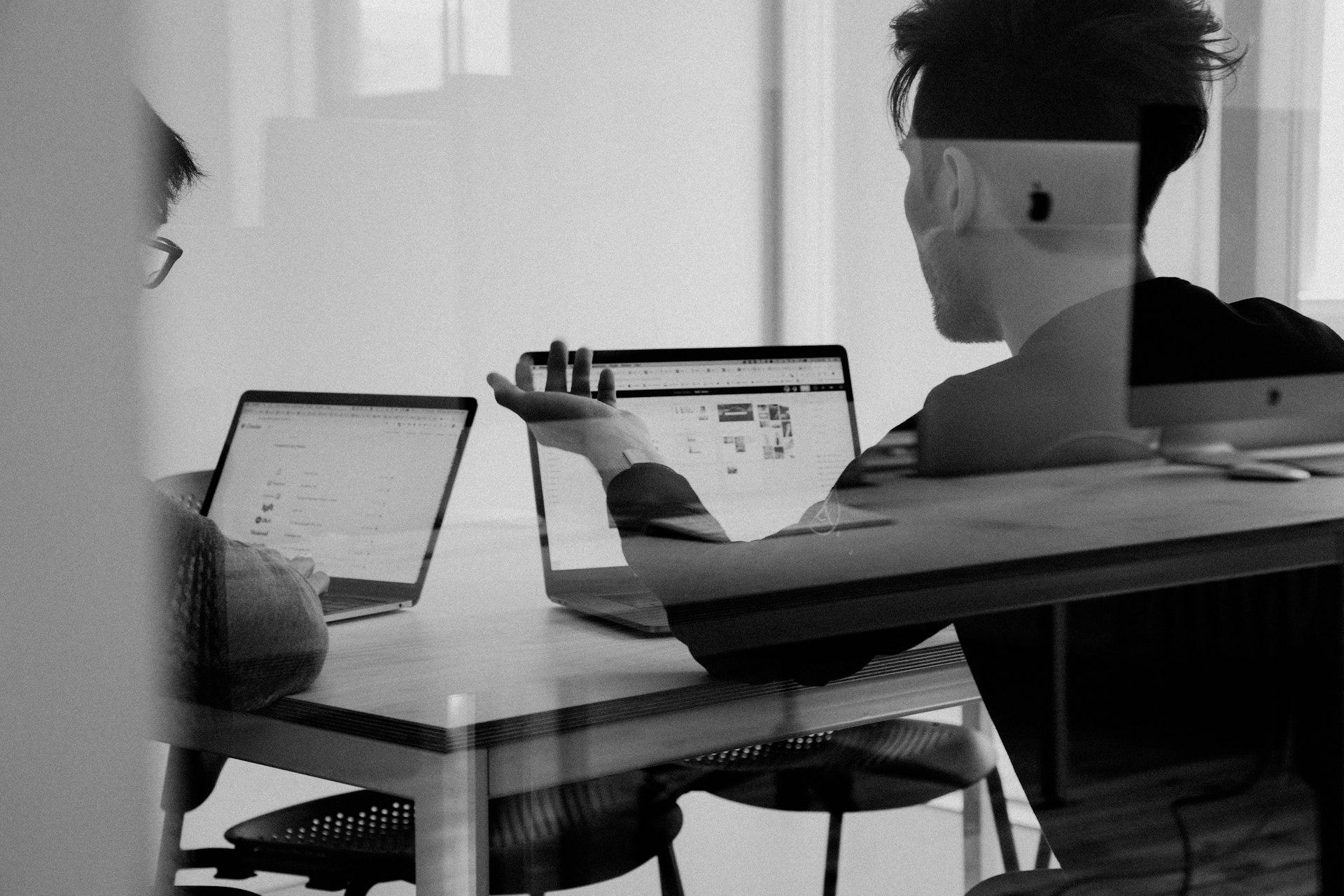 Two colleagues reviewing documents together at a wooden table